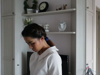 Young woman standing at home