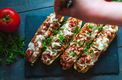 Close-up of stuffed zucchini boats with ground beef, spicy tomato sauce, cheese and fresh parsley