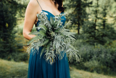 Midsection of woman holding plant