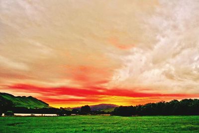 Scenic view of field against dramatic sky