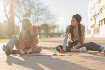 Young woman writing on banner outdoors