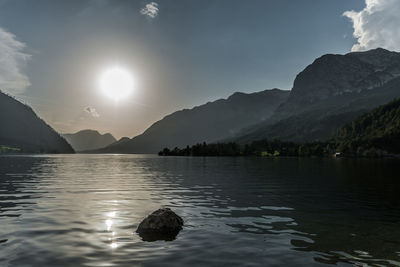 Scenic view of lake and mountains against sky during sunset