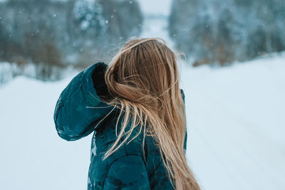 Rear view of woman standing on snow covered landscape