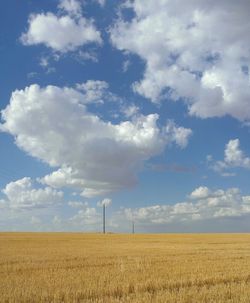 Scenic view of field against cloudy sky