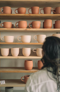 Rear view of woman in shelf