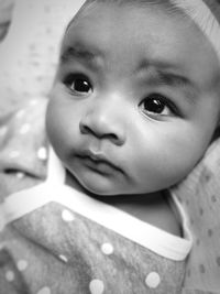 Close-up of cute baby on bed at home