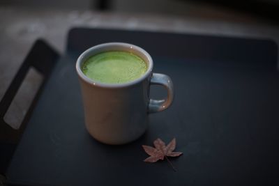 High angle view of matcha tea with leaf on table