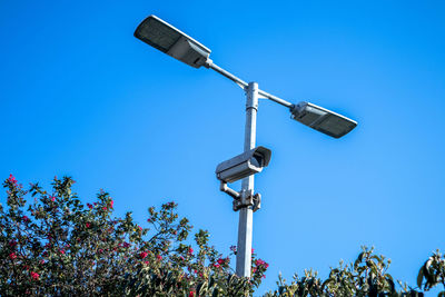 Low angle view of telephone pole against clear blue sky