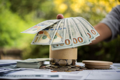 Midsection of businessman holding paper currency on table