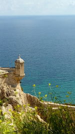 Lighthouse by sea against sky