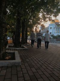 Rear view of people walking on street in city