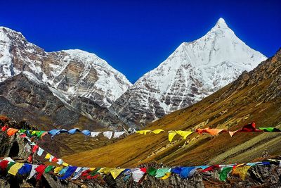 Scenic view of snowcapped mountains against clear blue sky