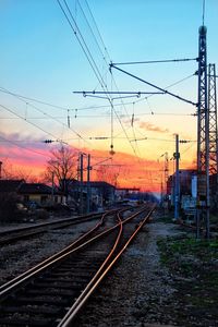 Railroad tracks against sky at sunset