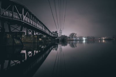 Bridge over river in city against sky