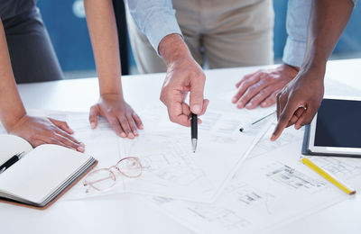 Midsection of businessman working on blueprint