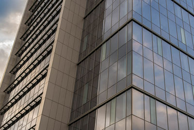 Low angle view of glass building against sky