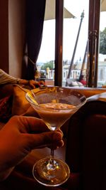 Close-up of hand holding wine glass on table at restaurant