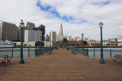 City at waterfront against cloudy sky