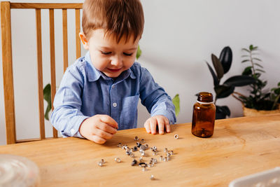 High angle view of boy looking at table