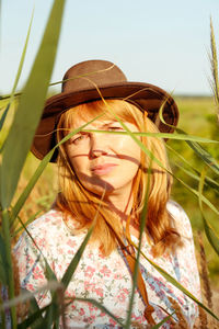 Closeup outdoor portrait of beautiful young blonde woman near reed and pampas grass. plant art