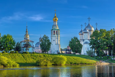 Church by lake against sky