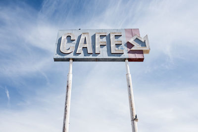 Low angle view of information sign against sky