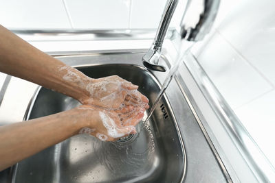 Midsection of person in kitchen at home