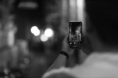 Cropped hand of woman using mobile phone