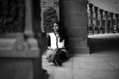 Man sitting on statue against building