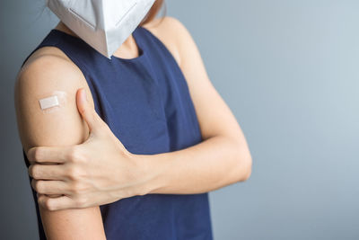 Midsection of woman holding hands against white background