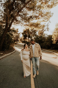 Rear view of couple walking on road
