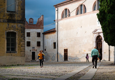 People walking on street amidst buildings in city