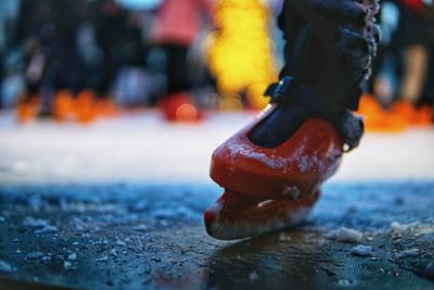 Close-up of shoes on wood in city