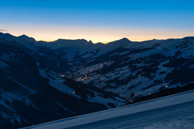 Scenic view of snowcapped mountains against clear sky during sunset