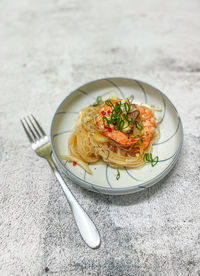 Glass noodle with prawns on white plate on white marble table