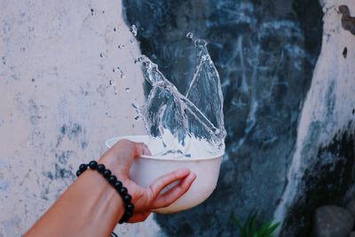 Hand splashing water in bowl