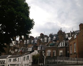 Buildings against cloudy sky