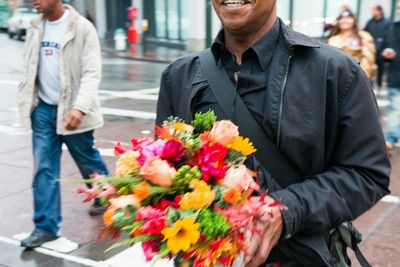 Midsection of woman holding flowers