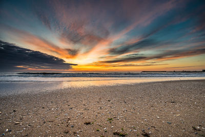 Scenic view of beach against sky during sunset