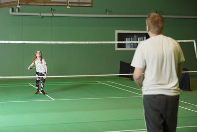 Girl and man playing badminton
