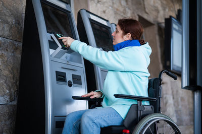 Side view of disabled woman near vending machine