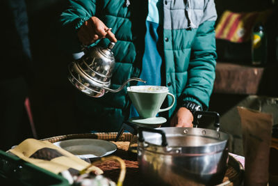 Midsection of man preparing coffee in kitchen