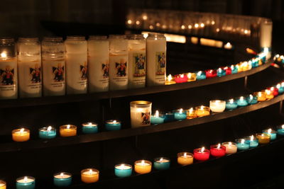 Row of illuminated candles in temple