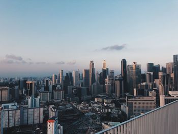 Aerial view of buildings in city against sky