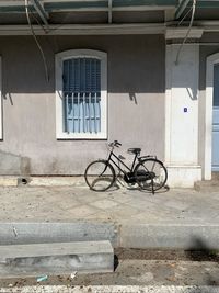 Bicycle parked on street by building