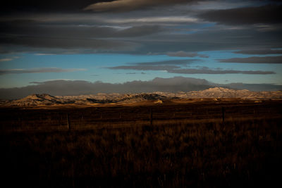 Scenic view of silhouette field against sky at sunset