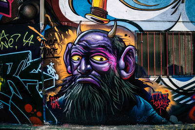 Close-up portrait of multi colored graffiti on wall