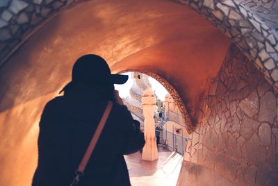 Rear view of man standing against wall