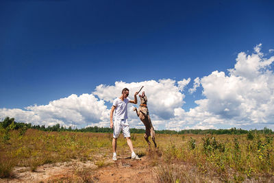 Full length of woman standing on field against sky