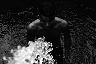 Portrait of shirtless man standing in water